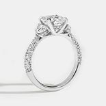 A white gold ring with three stones in center and side stones on band.