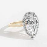 Two toned ring set with pear stone with a halo of stones around it.