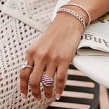 A woman's hand with long nails and fashion rings.