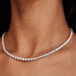 A woman's neck with a tennis necklace.