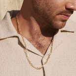 A man wearing a yellow gold chain necklace.